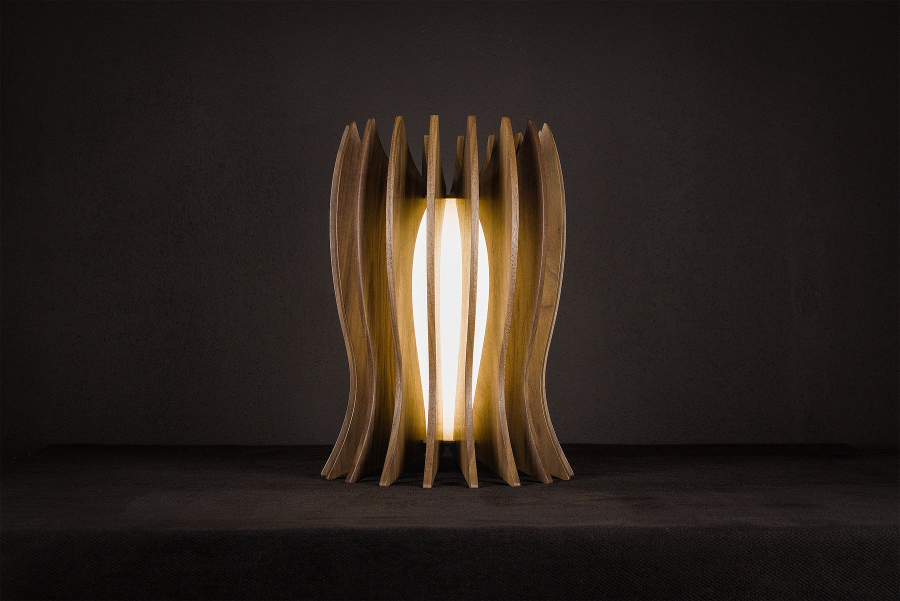 Handcrafted LED table lamp made from solid Canaletto walnut with a gold lacquered stainless steel frame, pure linen wrapped plexiglass diffuser and warm 2700K LED lighting, artisan made in Italy.