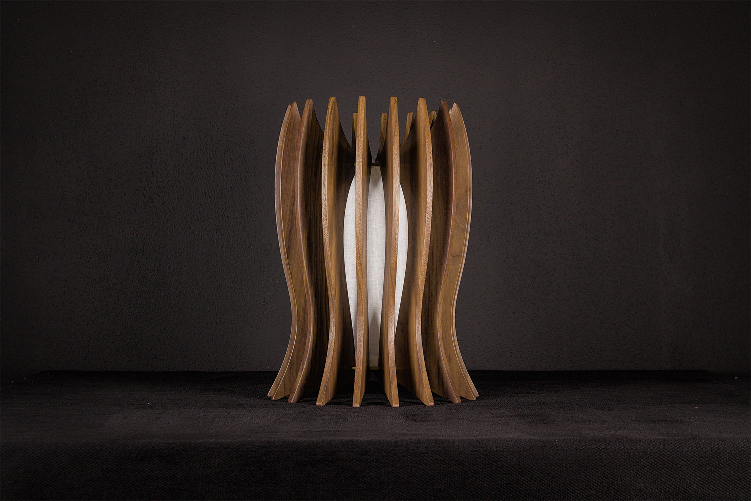 Modern Italian artisan table lamp crafted from solid Canaletto walnut featuring a gold lacquered stainless steel structure, linen-covered plexiglass shade and integrated warm white 2700K LED illumination.