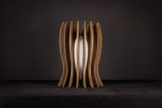 Modern Italian artisan table lamp crafted from solid Canaletto walnut featuring a gold lacquered stainless steel structure, linen-covered plexiglass shade and integrated warm white 2700K LED illumination.