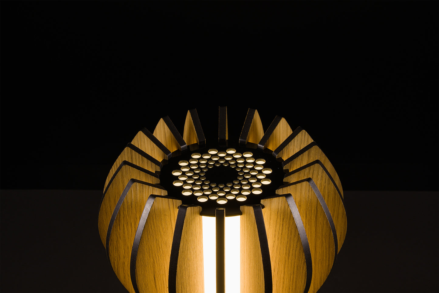 Handmade Casper lamp in natural oak veneer, Italian luxury design, soft warm LED glow, studio shot on black background.