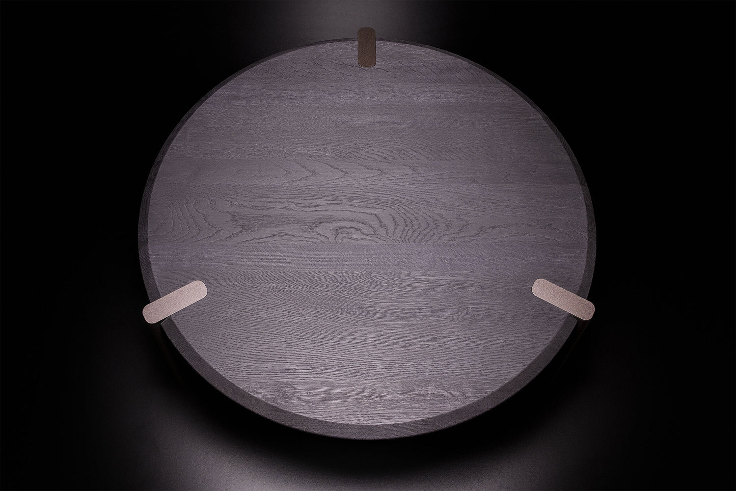 Luxury Edones round coffee table in black oak, minimal Italian design, handcrafted with bronze textured legs and attention to detail. By Vera Forma.