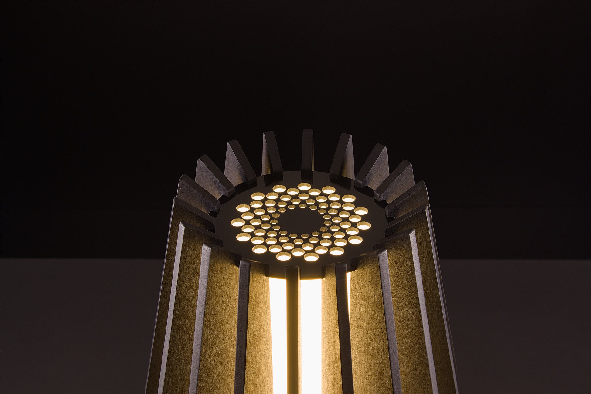 Handcrafted Futura lamp in dark stained walnut, Italian luxury lighting, soft warm LED glow, studio black backdrop.