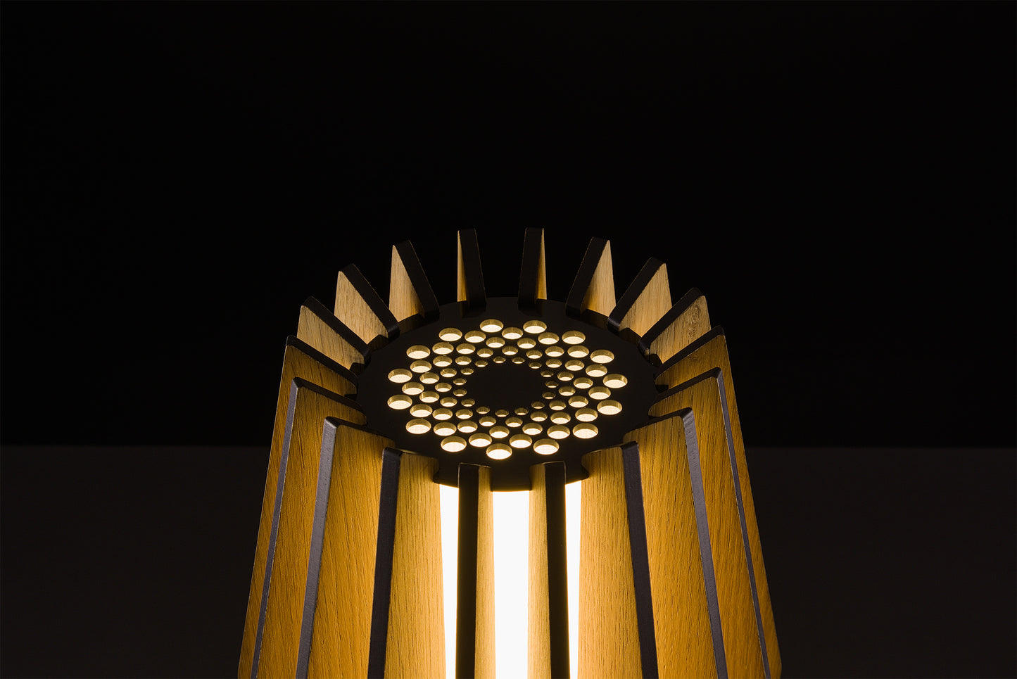 Handmade Futura lamp in natural oak veneer, Italian design excellence, soft warm LED light, photographed in studio on black.