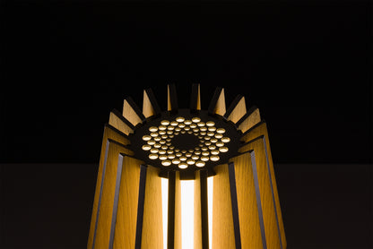 Handmade Futura lamp in natural oak veneer, Italian design excellence, soft warm LED light, photographed in studio on black.