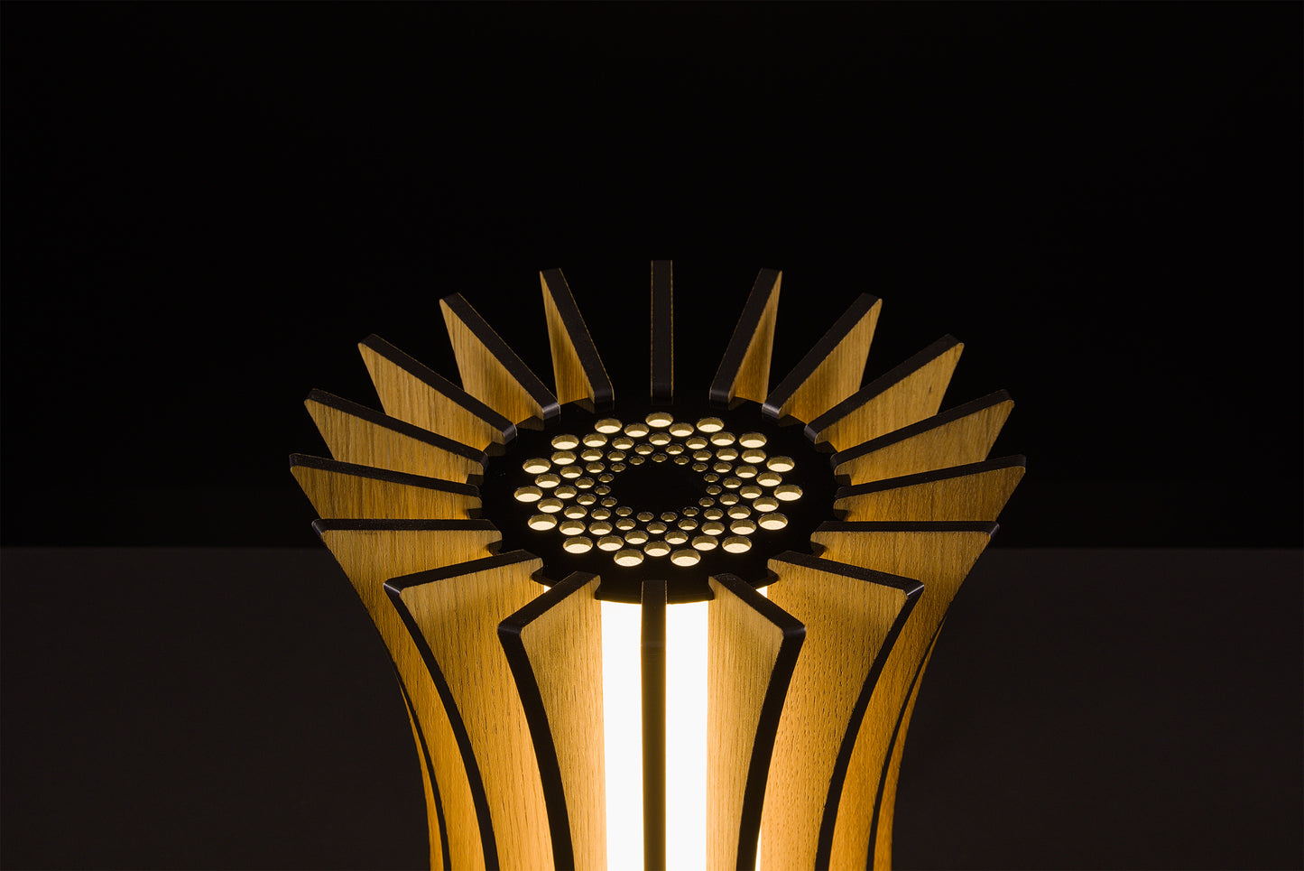 Handmade Gothica lamp in natural oak, Italian luxury design, soft warm LED glow, photographed on black background.