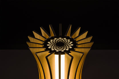 Handmade Gothica lamp in natural oak, Italian luxury design, soft warm LED glow, photographed on black background.