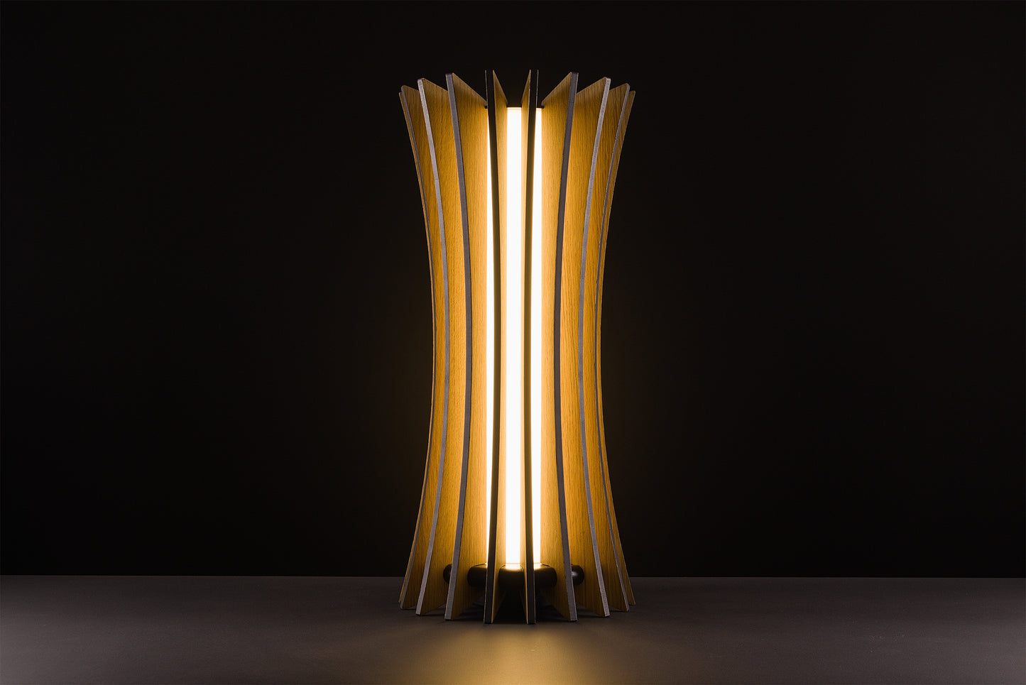 Vertigo table lamp in natural oak, handcrafted Italian luxury design, warm 2700K LED, photographed in studio on black background.