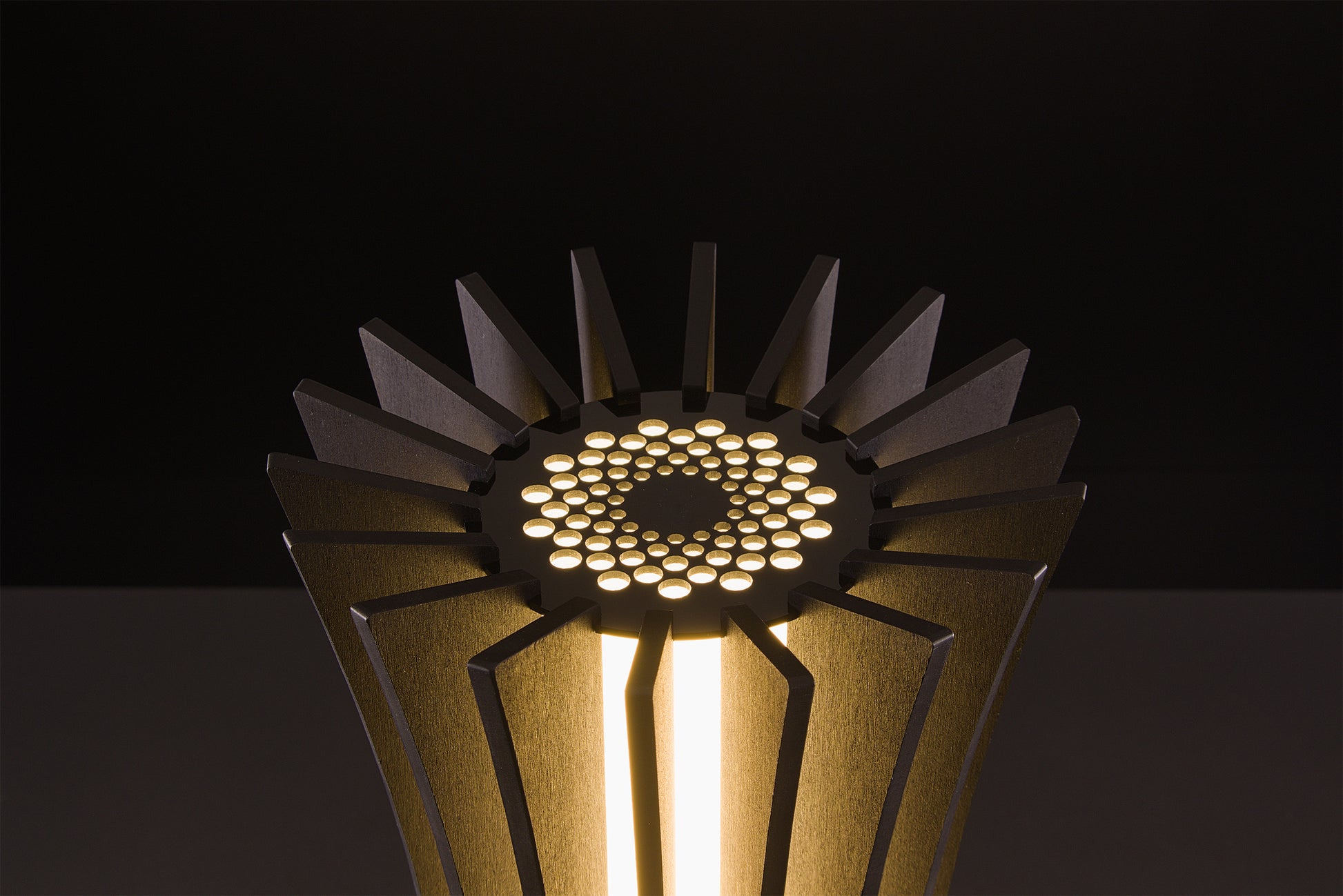 Luxury Vertigo lamp in dark walnut, Italian handmade craftsmanship, soft warm LED light, photographed on black studio backdrop.